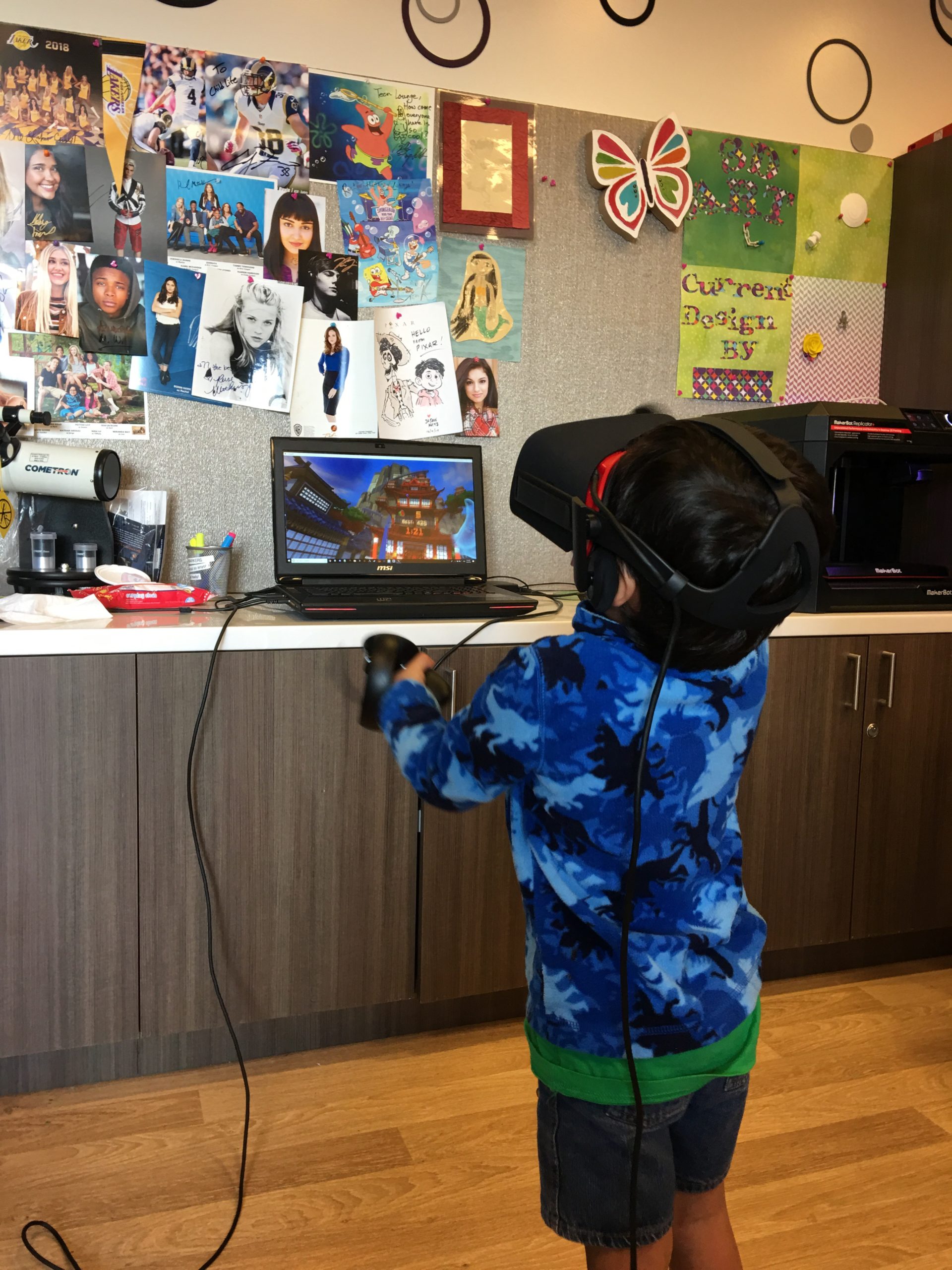 A child in a hospital playroom, immersed in a virtual-reality game with controllers in hand